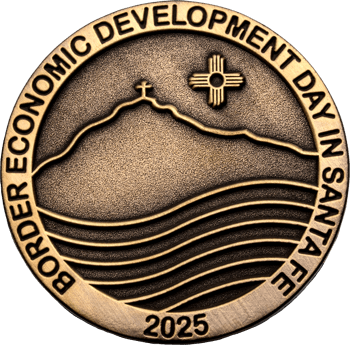 Antique bronze challenge coin for Border Economic Development Day in Santa Fe 2025 featuring a mountain landscape and Zia symbol.