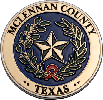 McLennan County Texas challenge coin featuring a central gold star, olive and oak branches, and a red ribbon on a blue background.