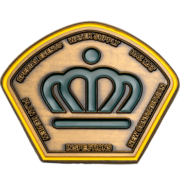 Pentagonal antique bronze challenge coin featuring a central green enamel crown surrounded by text for inspections and water supply.