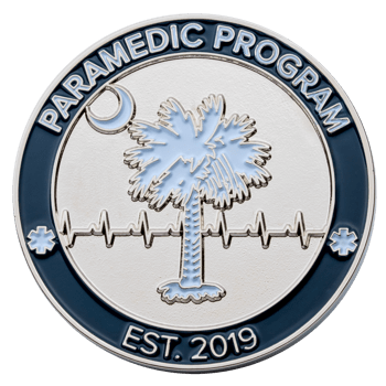 Circular challenge coin featuring a palmetto tree, crescent moon, and EKG line for a Paramedic Program established in 2019.