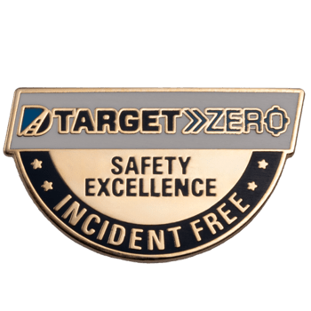 Semicircle lapel pin featuring Target Zero logo with Safety Excellence and Incident Free text in gold and black enamel.