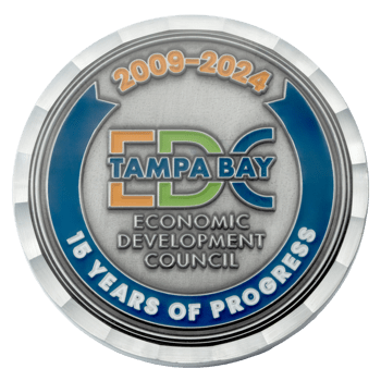 Silver challenge coin for the Tampa Bay Economic Development Council featuring 15 Years of Progress text and a blue outer ring with beveled edges.