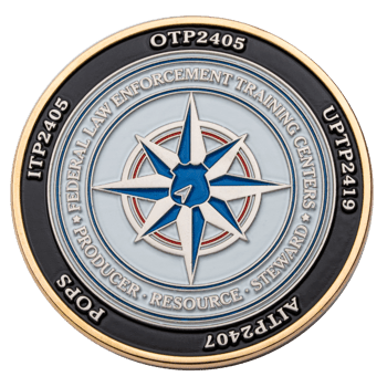 Gold and enamel challenge coin featuring the Federal Law Enforcement Training Centers logo with a blue and white compass rose design.