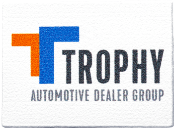 Rectangular coaster featuring the Trophy Automotive Dealer Group logo with stylized orange and blue T shapes.