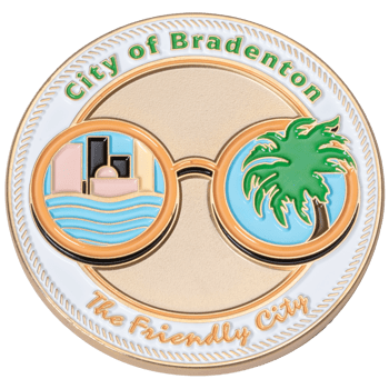 City of Bradenton challenge coin featuring sunglasses reflecting a skyline and a palm tree on a white and gold background.