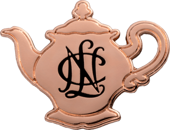 Polished rose gold teapot-shaped lapel pin featuring an intricate black script monogram in the center.