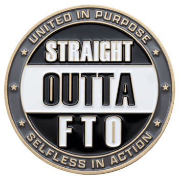 Circular challenge coin with black and white enamel reading Straight Outta FTO with United in Purpose and Selfless in Action on the gold border.