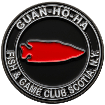 Circular challenge coin with red arrowhead emblem and Guan-Ho-Ha Fish & Game Club Scotia N.Y. text in white enamel.